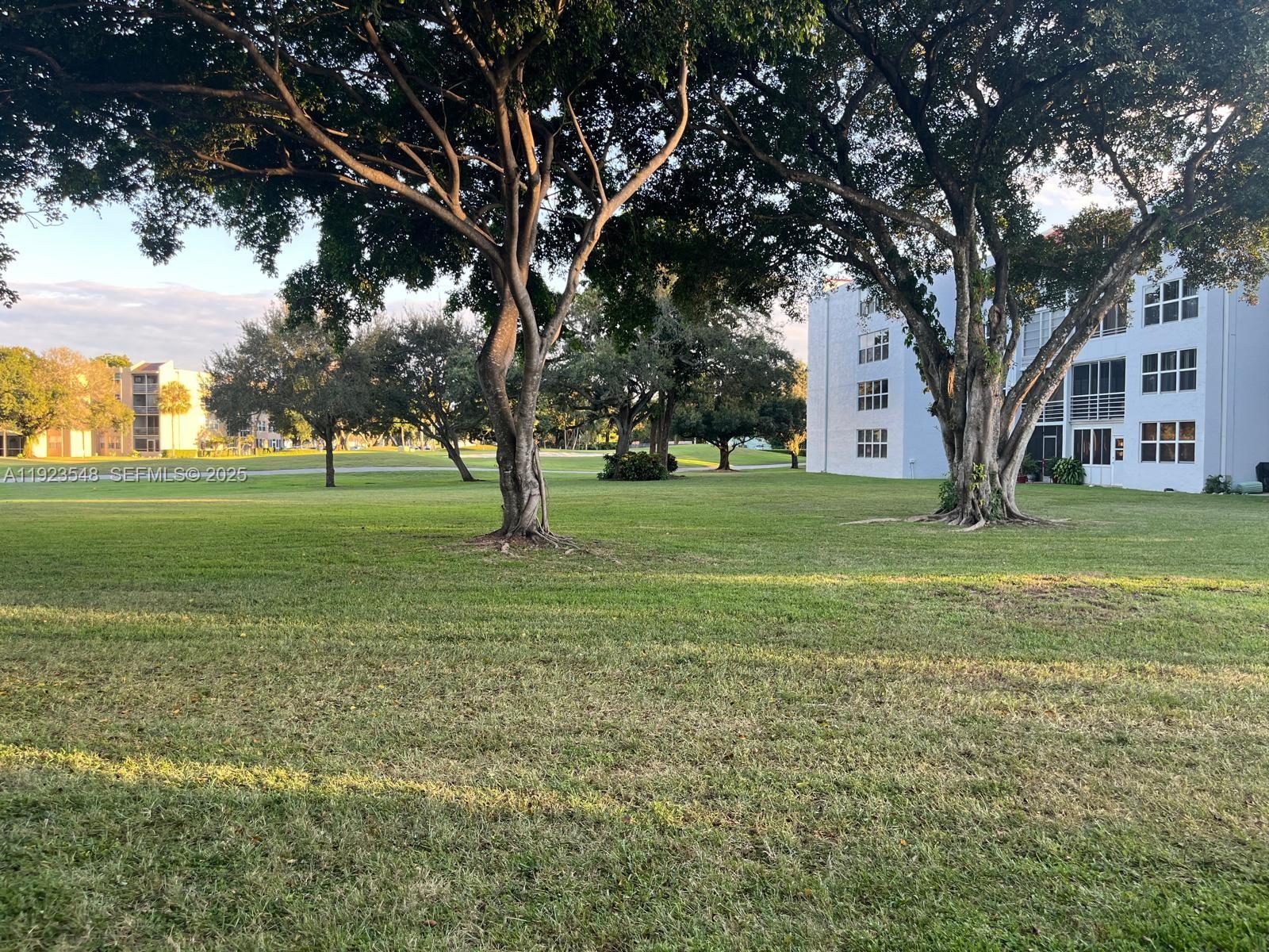 9421 Evergreen Place, Unit 107 Davie, FL 33324 - Photo 24 of 49 a view of grassy field with benches and trees all around