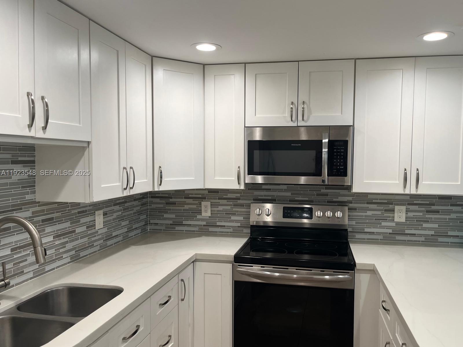 9421 Evergreen Place, Unit 107 Davie, FL 33324 - Photo 3 of 49 a kitchen with granite countertop a sink a stove and cabinets
