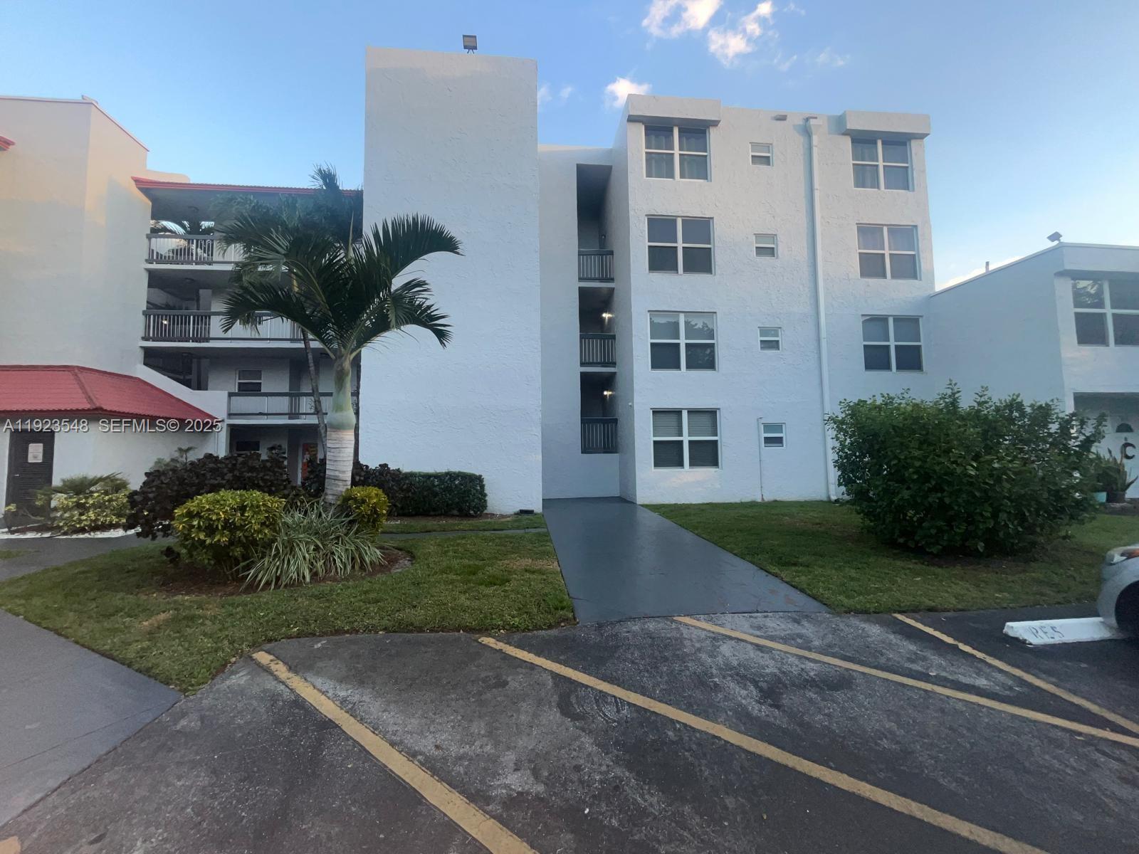 9421 Evergreen Place, Unit 107 Davie, FL 33324 - Photo 31 of 49 a front view of a residential apartment building with a yard