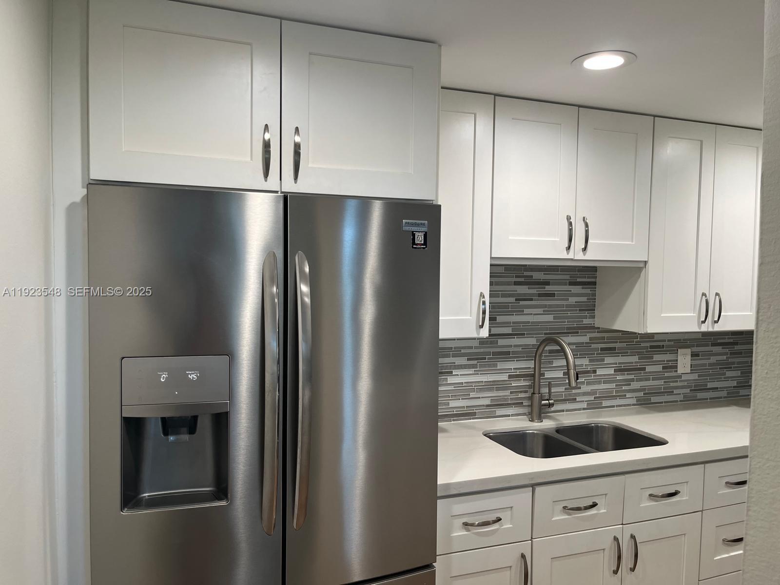 9421 Evergreen Place, Unit 107 Davie, FL 33324 - Photo 4 of 49 a kitchen with stainless steel appliances granite countertop a refrigerator and a sink