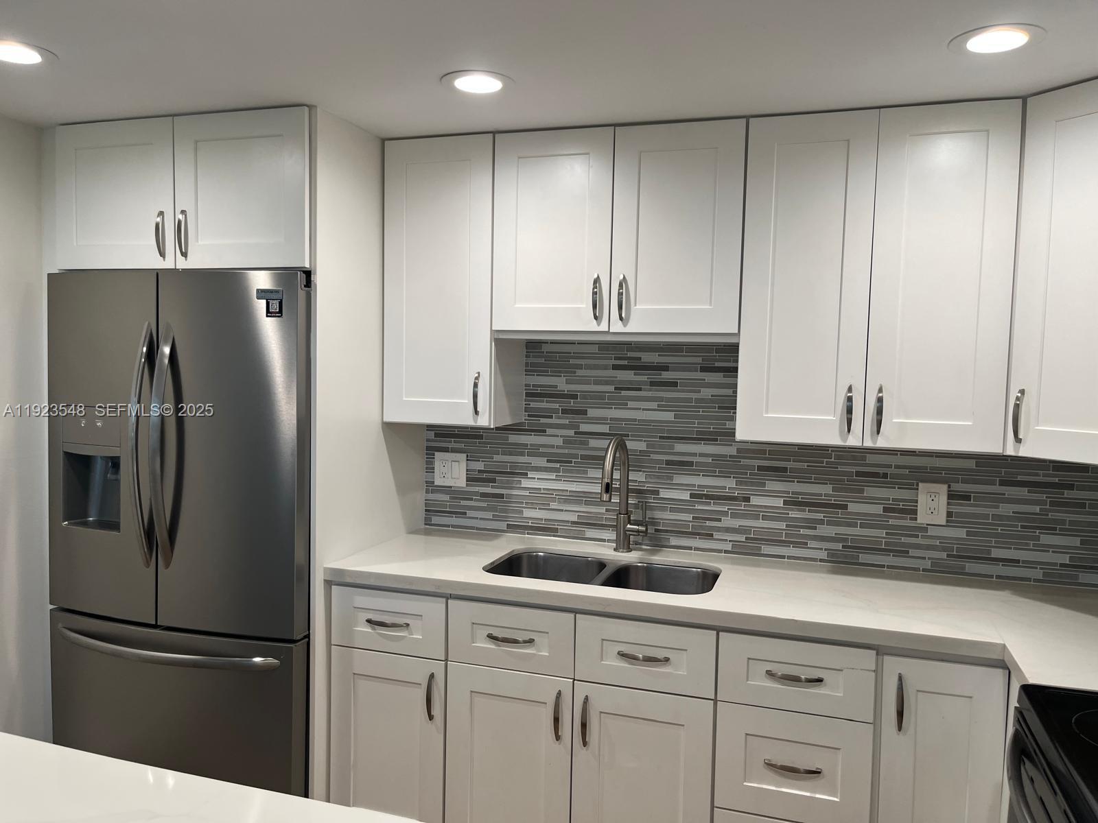 9421 Evergreen Place, Unit 107 Davie, FL 33324 - Photo 5 of 49 a kitchen with appliances a refrigerator and cabinets
