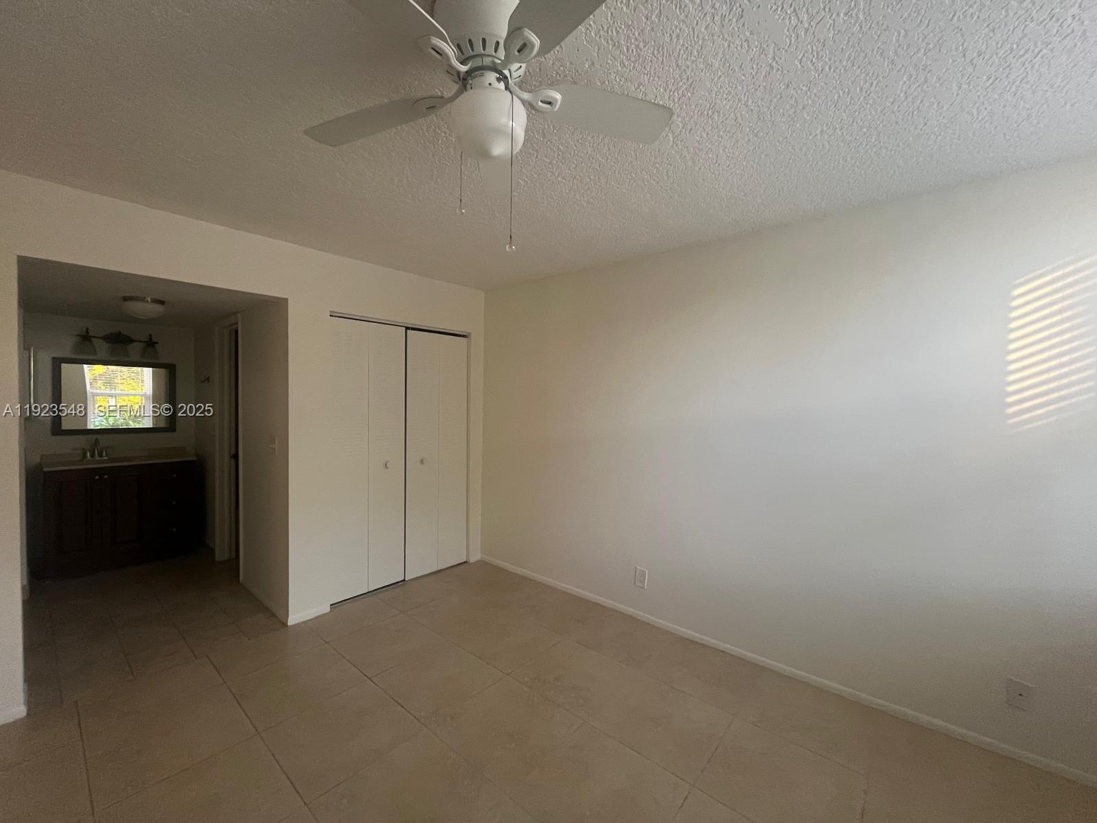 9421 Evergreen Place, Unit 107 Davie, FL 33324 - Photo 9 of 49 an empty room with a bathroom and a ceiling fan