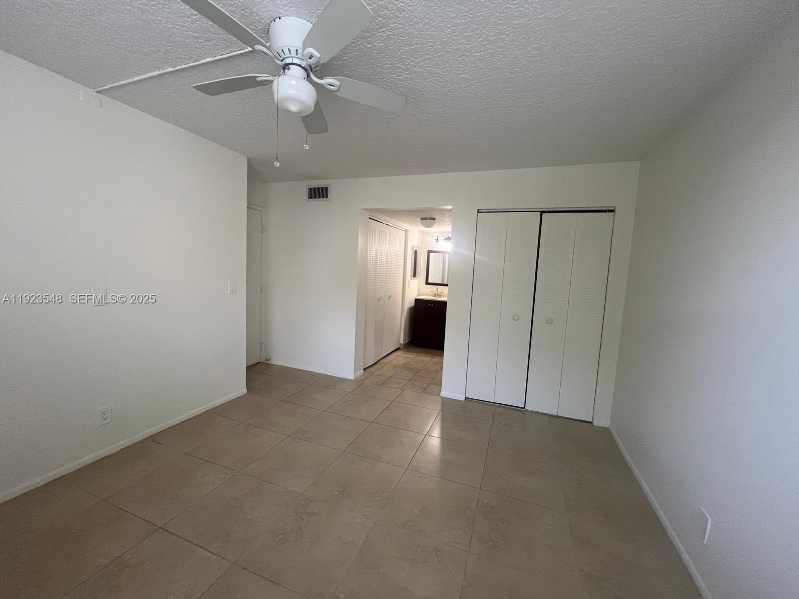9421 Evergreen Place, Unit 107 Davie, FL 33324 - Photo 10 of 49 an empty room with closet and a ceiling fan