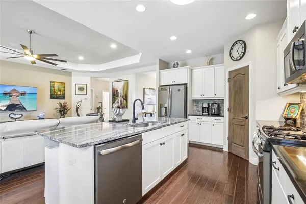 a kitchen with white cabinets and stainless steel appliances
