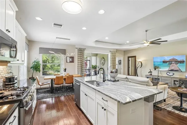 a kitchen with granite countertop a stove and a wooden floors