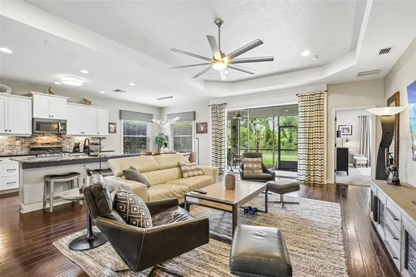a living room with furniture wooden floor and a large window