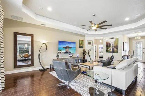 a living room with furniture a large window and wooden floor