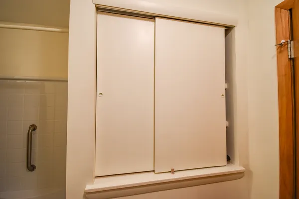 a view of a hallway with wooden floor and closet