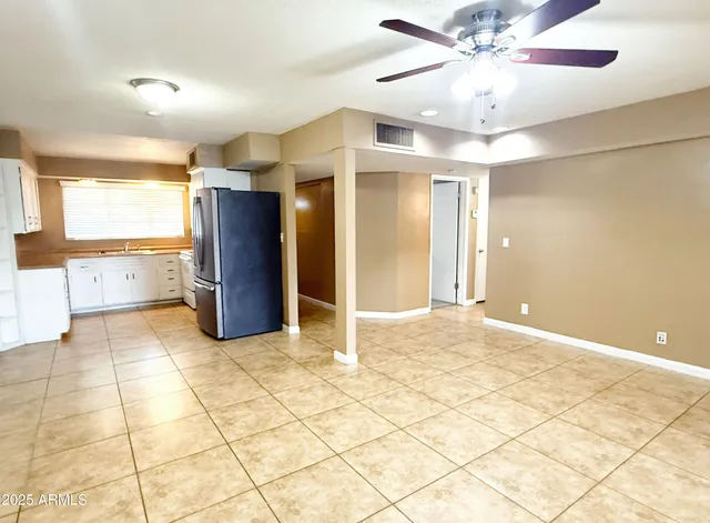 a view of a livingroom with a chandelier fan and windows