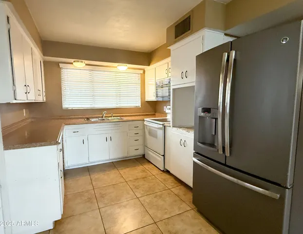 a kitchen with stainless steel appliances a refrigerator sink and cabinets