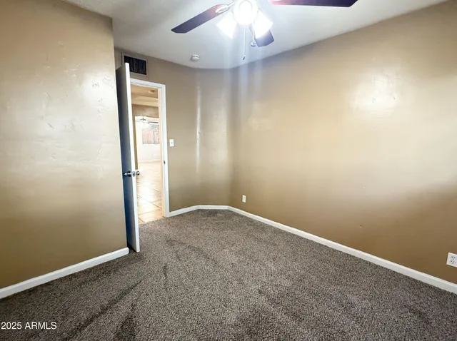 an empty room with a chandelier fan