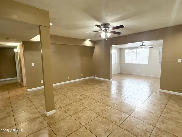 a view of a livingroom with a chandelier fan and windows
