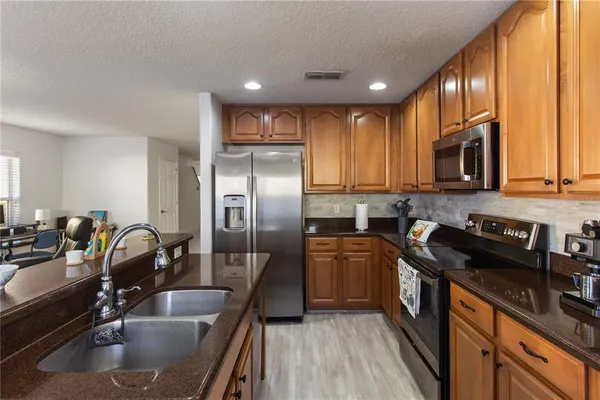 a kitchen with kitchen island granite countertop a sink stove and refrigerator