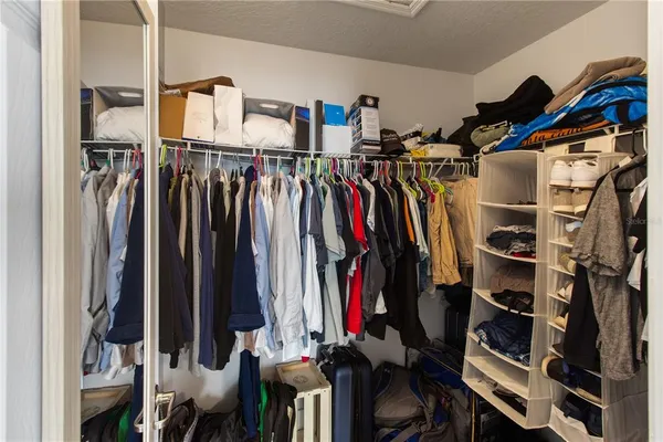a view of walk in closet with clothes and shoes