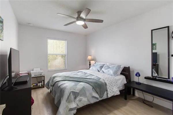 a bedroom with a bed tv and a window