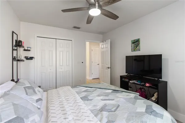 a bedroom with a bed and a flat tv screen on dresser