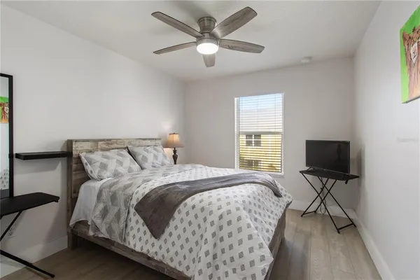 a bedroom with bed tv and window