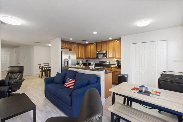 a living room with stainless steel appliances kitchen island granite countertop furniture and a view of kitchen