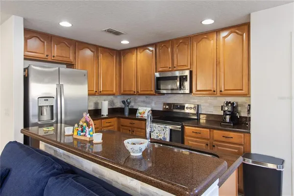 a kitchen with stainless steel appliances granite countertop a refrigerator a stove top oven a sink and dishwasher