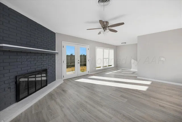 a view of an empty room with a fireplace and a window
