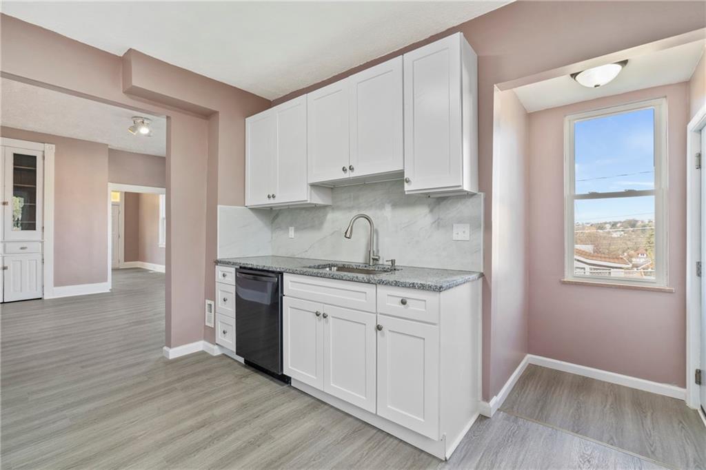 711 9th Avenue Irwin, PA 15642 - Photo 14 of 26 a kitchen with granite countertop white cabinets and white appliances