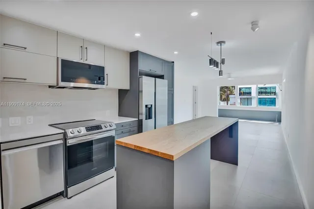 a kitchen with stainless steel appliances a stove microwave and sink