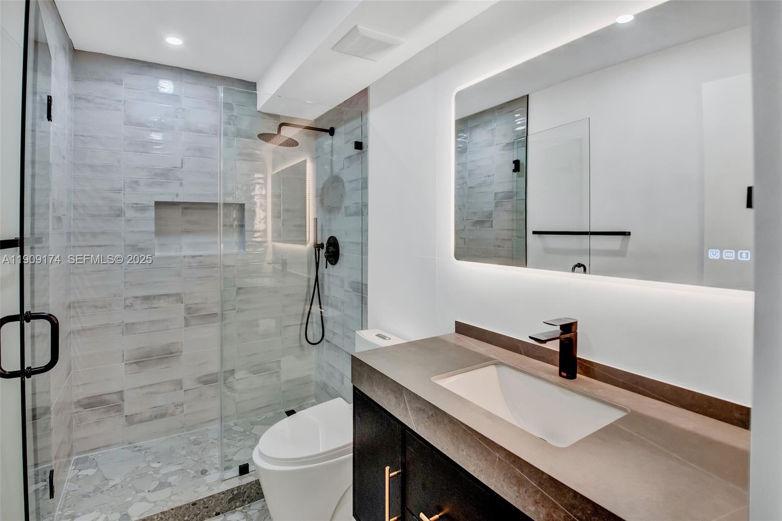 54 Isle Of Venice Drive, Unit 7 Fort Lauderdale, FL 33301 - Photo 27 of 41 a bathroom with a sink toilet a mirror and shower