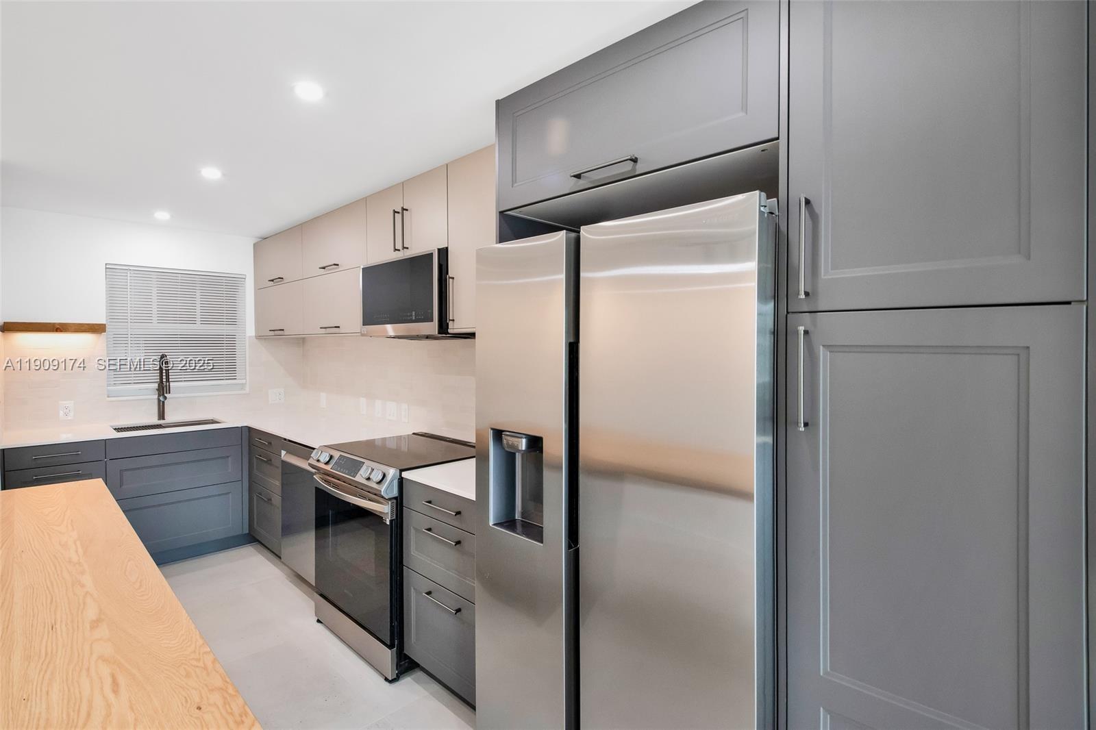 54 Isle Of Venice Drive, Unit 7 Fort Lauderdale, FL 33301 - Photo 5 of 41 a kitchen with stainless steel appliances granite countertop a refrigerator and a sink