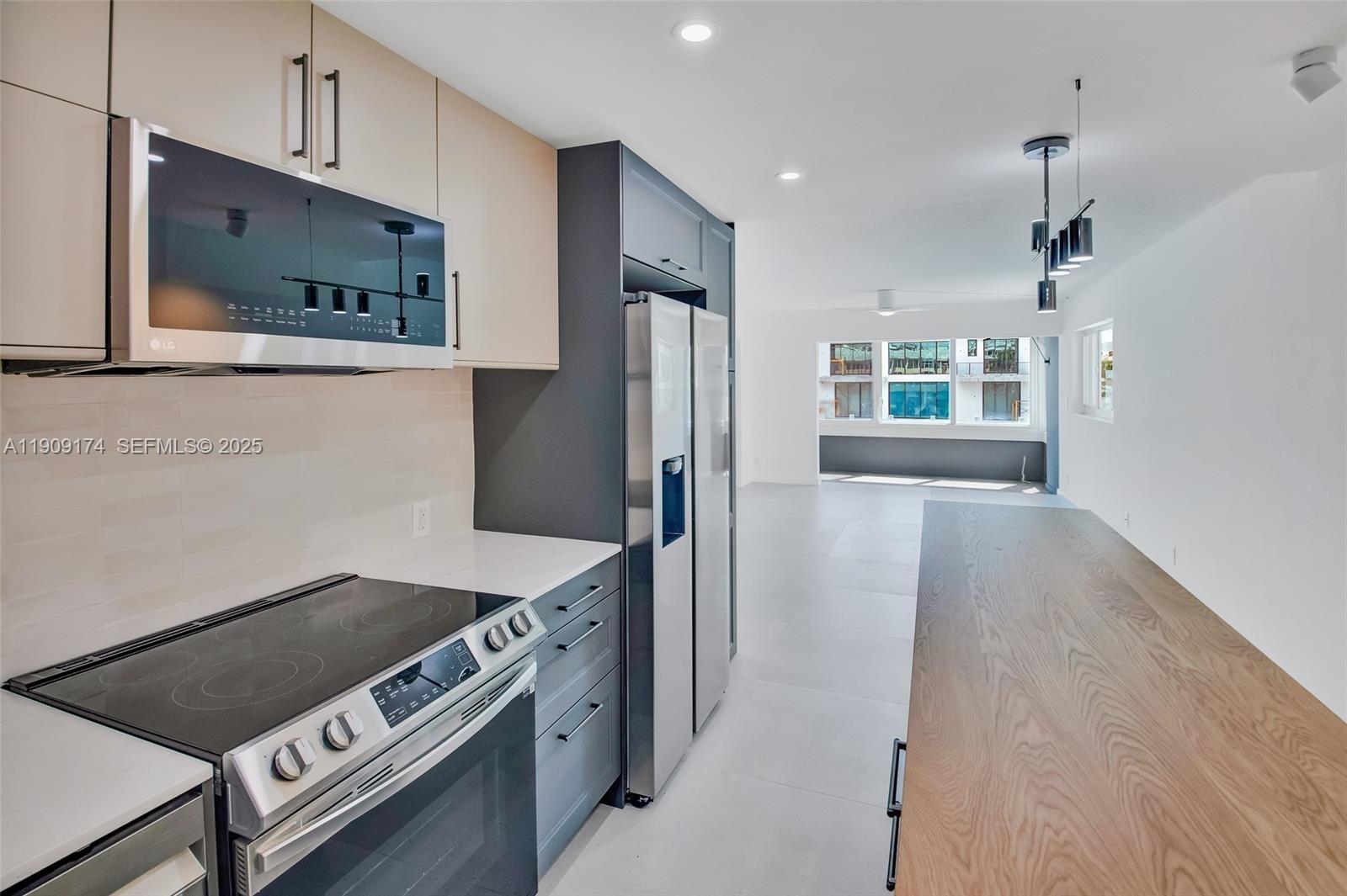54 Isle Of Venice Drive, Unit 7 Fort Lauderdale, FL 33301 - Photo 6 of 41 a kitchen with stainless steel appliances granite countertop a refrigerator a stove and a sink with wooden floor