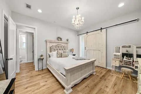 a bedroom with a bed and a chandelier