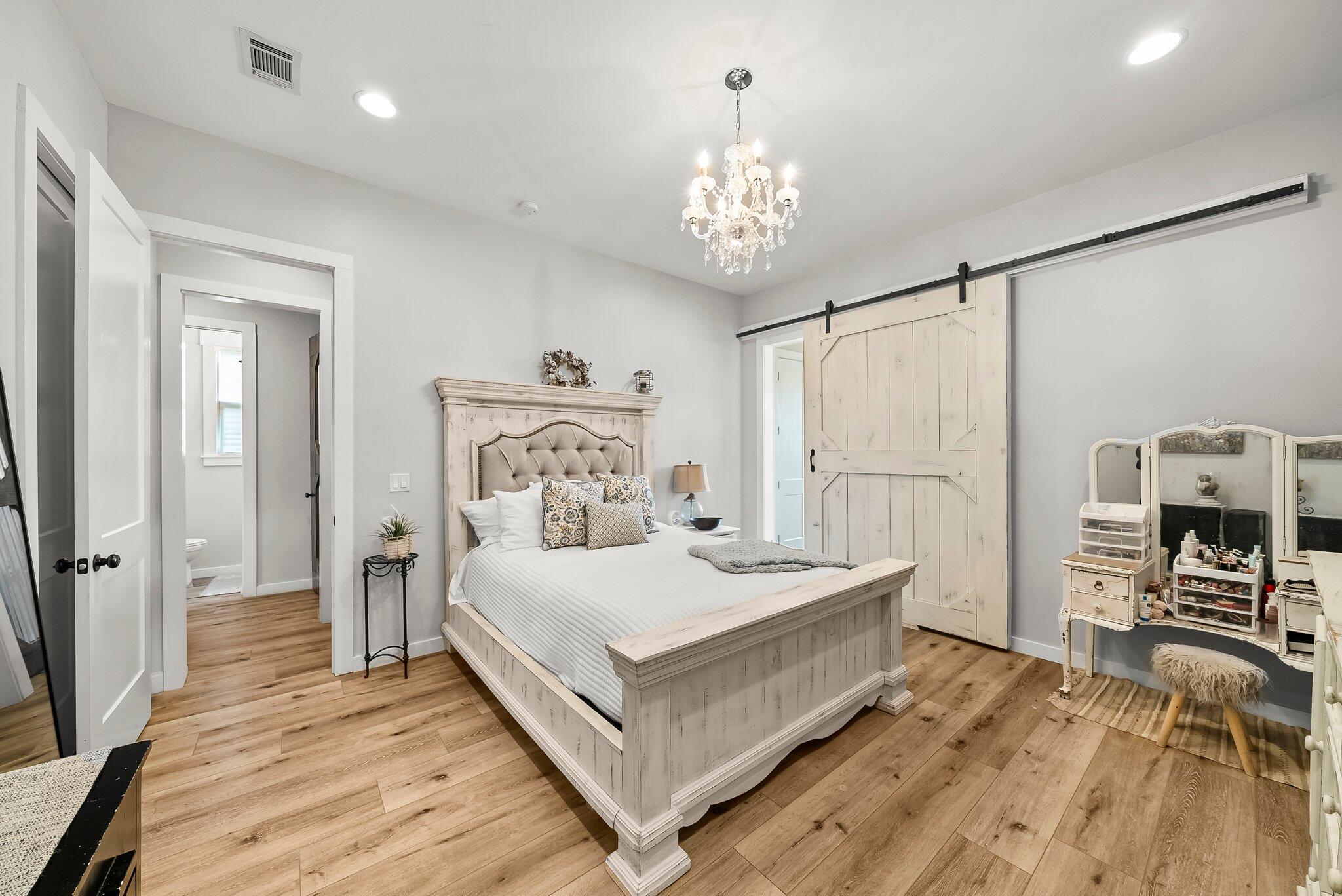 71 Childers Lane Freeport, FL 32439 - Photo 15 of 48 a bedroom with a bed and a chandelier