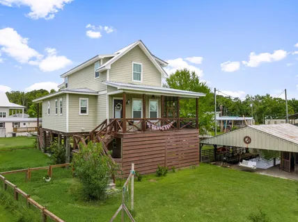 a view of house with a yard and sitting area