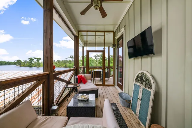a living room with furniture tv and a floor to ceiling window