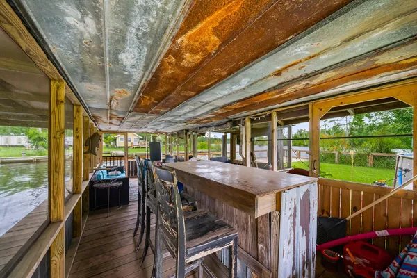 a view of a patio with table and chairs a floor to ceiling window with wooden floor