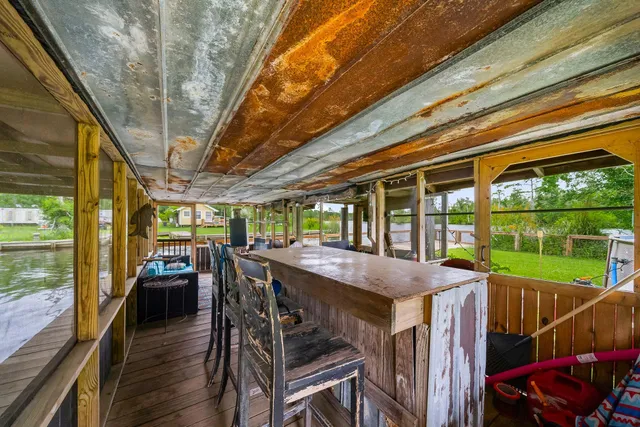 a view of a patio with table and chairs a floor to ceiling window with wooden floor