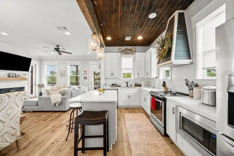 a large white kitchen with lots of counter space a sink and a stove