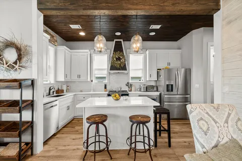 a kitchen with stainless steel appliances kitchen island granite countertop a sink and cabinets
