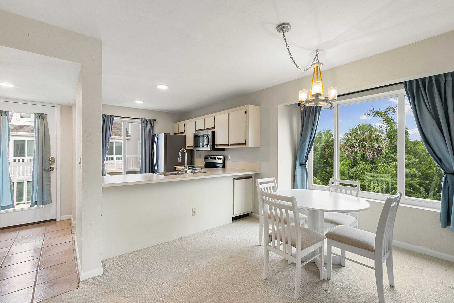 2189 San Marco Road, Unit 201 Marco Island, FL 34145 - Photo 10 of 27 a kitchen with stainless steel appliances kitchen island granite countertop a table and chairs in it