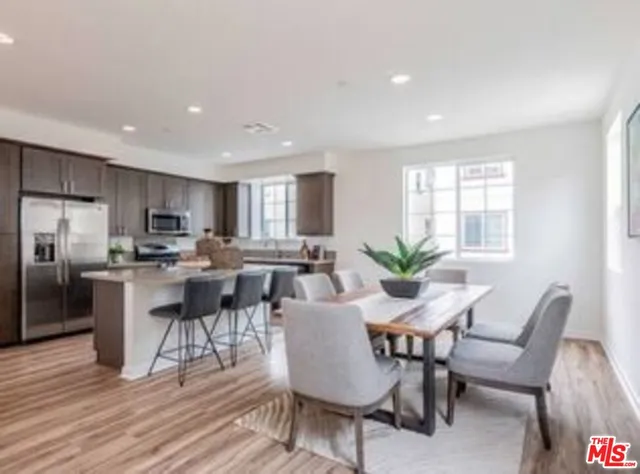 a view of a dining room with furniture a potted plant and wooden floor