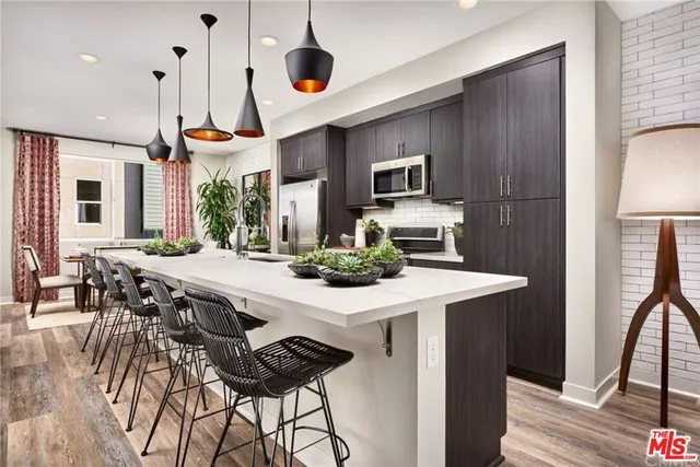 a kitchen with a table chairs refrigerator and microwave
