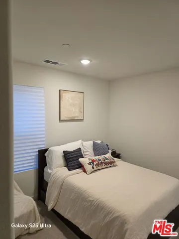 a bedroom with a bed and a lamp