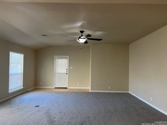 a view of an empty room with a ceiling fan