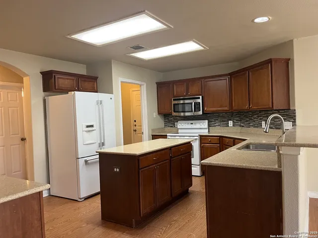 a kitchen with stainless steel appliances granite countertop a refrigerator stove and sink