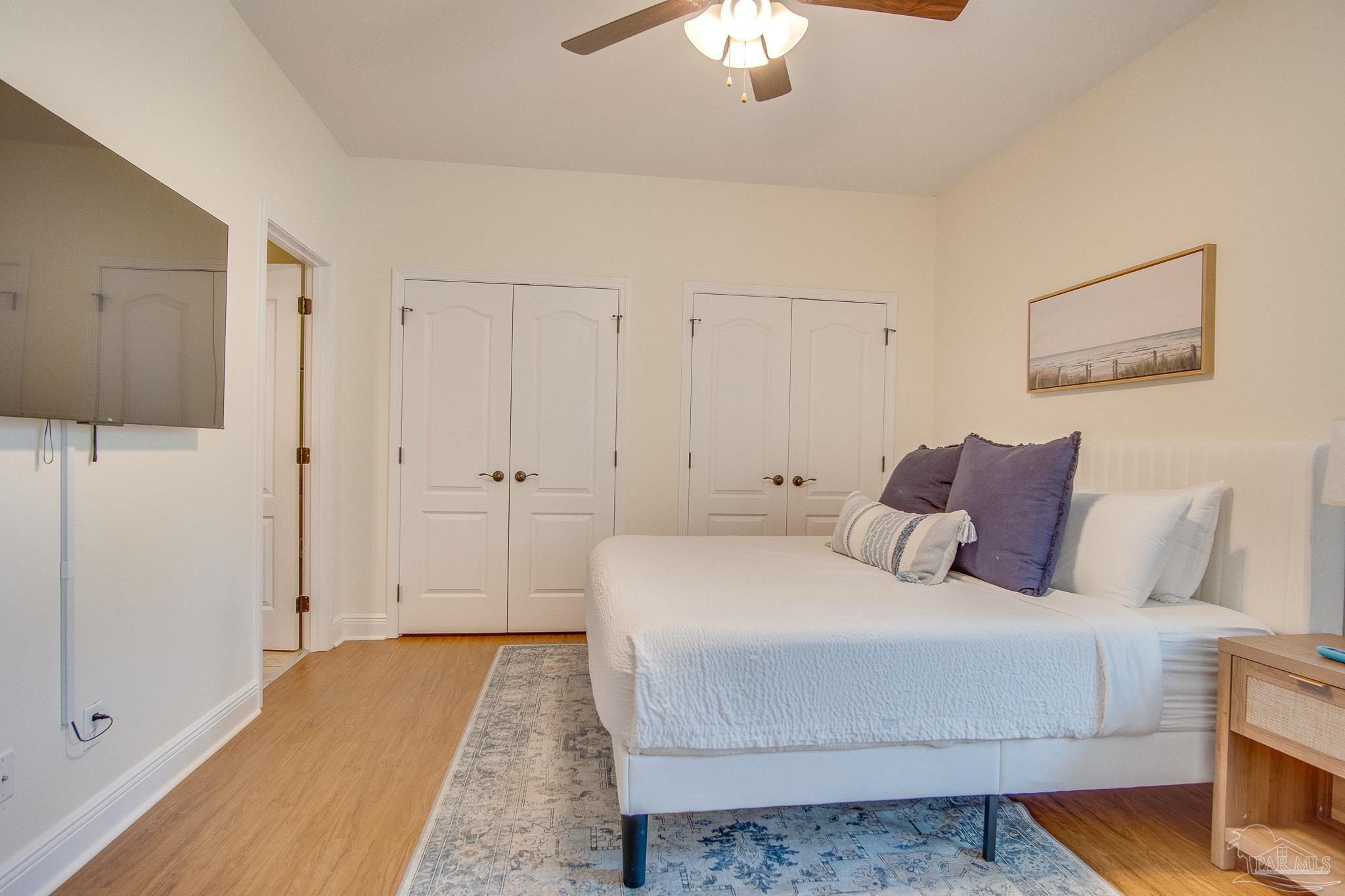 1768 Sound Haven Court Navarre, FL 32566 - Photo 16 of 39 a bedroom with a large bed and a chandelier