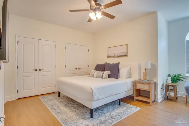 a bedroom with a bed and a ceiling fan