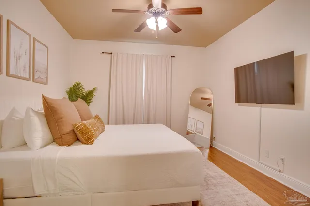 a bedroom with a bed and a flat tv screen on dresser