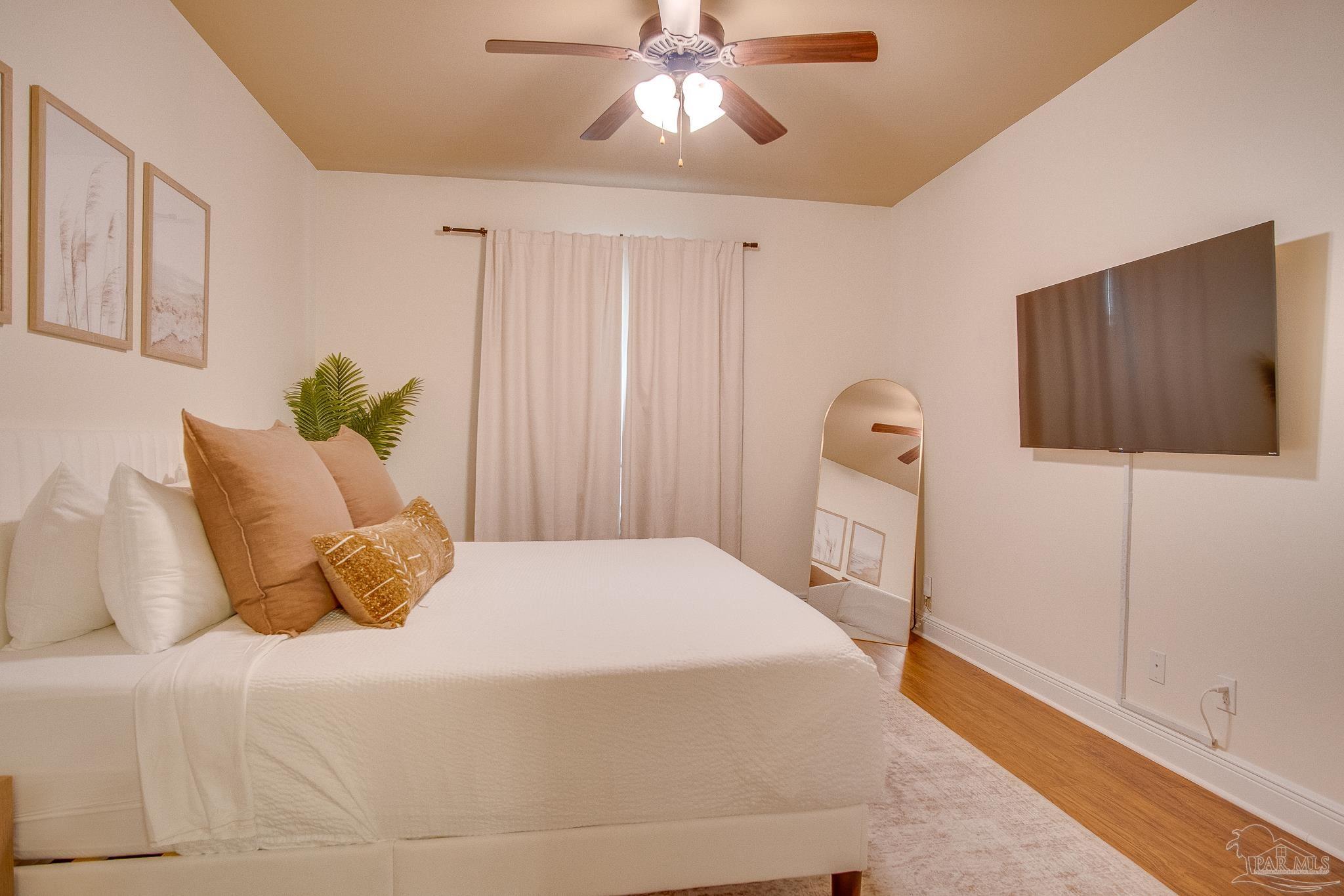 1768 Sound Haven Court Navarre, FL 32566 - Photo 20 of 39 a bedroom with a bed and a flat tv screen on dresser