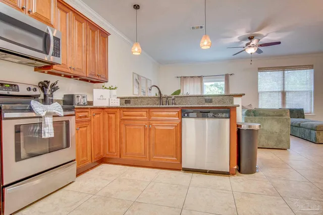 a kitchen with stainless steel appliances granite countertop a stove a sink and a microwave