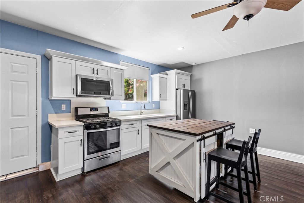 a kitchen that has a stove a sink and a refrigerator
