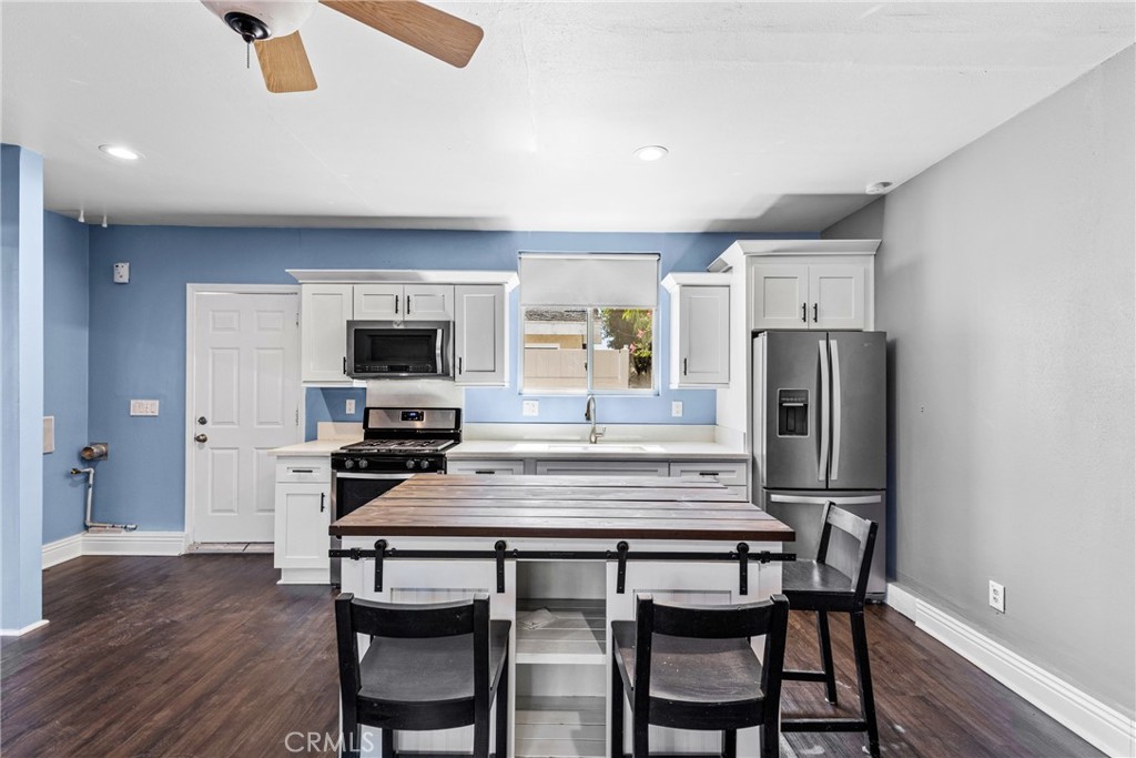 19403 Welby Way Reseda, CA 91335 - Photo 2 of 16 a kitchen with stainless steel appliances a dining table chairs and refrigerator
